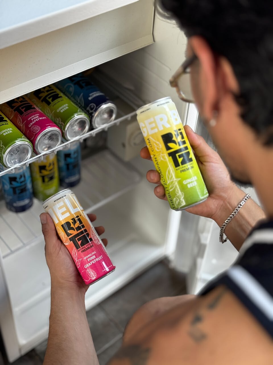 Persona eligiendo una lata BLITZ del refrigerador